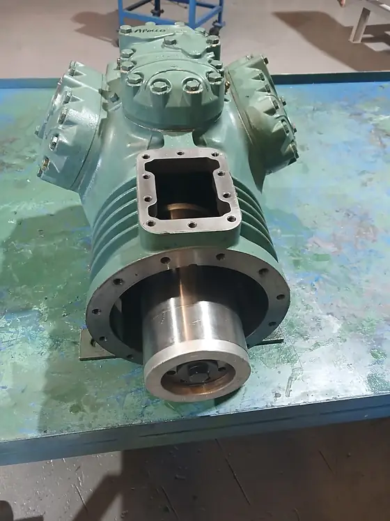 A piston compressor undergoing repair, internals exposed for work